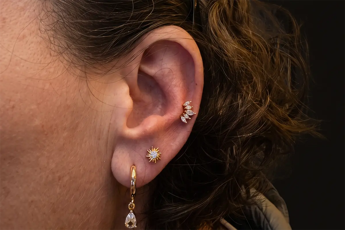 Kulak piercingleri için helix, rook ve lobe takı kombinasyonu